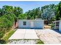Spacious backyard with concrete area and lots of trees around providing privacy and shade at 1221 E Hamilton Ave, Tampa, FL 33604