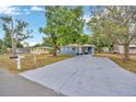Traditional style home with a long driveway, featuring a well-manicured lawn and a carport at 1304 N Ferrell St, Plant City, FL 33563