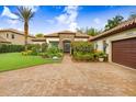 Charming single-story home with a clay tile roof, stone accents, and lush, colorful landscaping at 14910 Tom Fazio Ct, Tampa, FL 33626