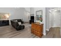 A well-lit living room offers an oversized sofa, hardwood floors, chandelier lighting, and neutral paint at 200 Pinewinds Blvd, Oldsmar, FL 34677