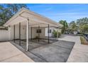 Spacious covered carport attached to a white single-story house with concrete flooring at 202 W Azalea Ave, Tampa, FL 33612