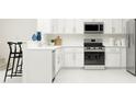 Well-lit kitchen boasts stainless steel appliances, white cabinetry, and modern fixtures at 218 27Th Se St, Ruskin, FL 33570
