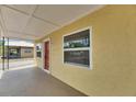 Side view of a sunny yellow home featuring a quaint front porch and large windows at 2402 Harper St, Tampa, FL 33605