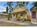 Charming yellow home with a welcoming front porch, complemented by fresh landscaping and a well-maintained yard at 2402 Harper St, Tampa, FL 33605