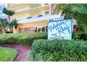 Close-up of the Dolphin Reef condo sign with lush landscaping, displaying the property's coastal charm at 2504 Gulf Blvd # 201, Indian Rocks Beach, FL 33785