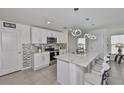 Bright kitchen with a large island, pendant lighting, and stainless steel appliances at 2858 Star Anise Ln, Wimauma, FL 33598