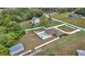 Aerial view of property highlighting pool, fenced yard, and surrounding greenery at 30703 San An Rd, San Antonio, FL 33576