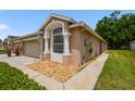 Single-story home featuring an attached two-car garage and low-maintenance landscaping at 31105 Whitlock Dr, Wesley Chapel, FL 33543
