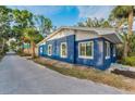 A quaint two-story blue home with white trim featuring well-maintained landscaping at 330 Pineapple St, Tarpon Springs, FL 34689