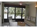 Cozy sunroom offering views of the lake, with comfortable seating and tile flooring at 3861 Sailmaker Ln # 3861, Holiday, FL 34691