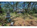 Two-story home with covered parking nestled among mature trees and lush landscaping at 420 Hanby St, Crystal Beach, FL 34681