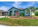 Beautiful home featuring teal paint, red front door, manicured lawn and a palm tree at 5103 Rushbrook Rd, Land O Lakes, FL 34638