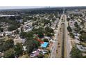 An aerial perspective shows the home's location within a lush, green area with a canal and cityscape in the distance at 6715 16Th N St, St Petersburg, FL 33702