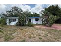 Modest one-story home with white exterior, blue trim, and mature landscaping at 6715 16Th N St, St Petersburg, FL 33702
