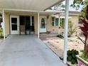 Charming home entrance with covered carport and decorative brick walkway leading to the front door at 7425 W Maryland W Ave, Hudson, FL 34667