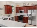 Stylish kitchen with stainless steel appliances, quartz countertops, and dark wood cabinetry at 7533 Dunbridge Dr, Odessa, FL 33556