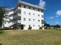 A bright white building with three stories, green grass, and neatly trimmed bushes at 8055 112Th St # 406, Seminole, FL 33772
