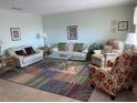 Comfortable living room with couches, a glass coffee table, an area rug, and natural light at 8055 112Th St # 406, Seminole, FL 33772