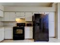 Efficient kitchen with white cabinets, laminate counters, black appliances and neutral tile flooring at 8110 Pond Shadow Ln, Tampa, FL 33635