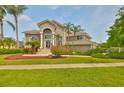 Elegant two-story home with a lush landscaped front yard and striking architectural details at 915 Symphony Isles Blvd, Apollo Beach, FL 33572