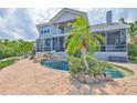 Private pool with a waterfall feature and lush tropical landscaping at 915 Symphony Isles Blvd, Apollo Beach, FL 33572