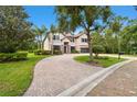 Stately home showcasing lush landscaping, a paver driveway, and an inviting facade, with great curb appeal at 11624 Calf Path Dr, Tampa, FL 33626