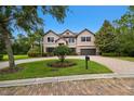 Charming two-story home boasts mature trees, lush lawn, and a paver driveway, with great curb appeal at 11624 Calf Path Dr, Tampa, FL 33626