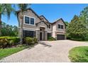 Stately home with a three-car garage, beautiful landscaping and a paver driveway, exuding curb appeal at 11624 Calf Path Dr, Tampa, FL 33626