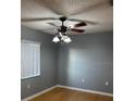 Cozy bedroom featuring a ceiling fan, a window for natural light, and neutral wall color at 12230 Skyler Ln, Spring Hill, FL 34609