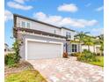 Charming two-story home with a brick driveway and well-manicured lawn at 13855 Sharp Hawk Dr, Riverview, FL 33569