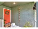 Inviting front porch with a vibrant red door adorned with a wreath and decorative driftwood at 1398 Lemon St, Clearwater, FL 33756