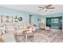 Bright living room with wood-look floors, comfortable seating, and a modern ceiling fan at 1398 Lemon St, Clearwater, FL 33756