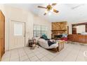 Cozy bedroom with a stone fireplace, ceiling fan, and tile flooring at 1609 S Valrico Rd, Valrico, FL 33594