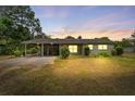 Charming home with well-maintained carport at dusk, ready for new owners at 1609 S Valrico Rd, Valrico, FL 33594