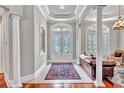 Welcoming foyer featuring decorative glass double doors, tile floor, and a comfortable seating area at 16124 Suncrest Shores Dr, Odessa, FL 33556