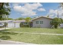Charming single Gathering home featuring a well-manicured lawn, long driveway and attached garage at 1624 Chateau Dr, Clearwater, FL 33756