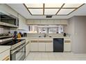 Well-lit kitchen featuring stainless steel appliances and updated white cabinets at 18400 Gulf Blvd # 1105, Indian Shores, FL 33785