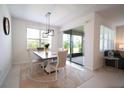 Bright dining room with stylish lighting fixture and sliding glass doors leading to the patio at 18933 Sailors Delight Pass, Land O Lakes, FL 34638