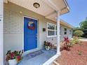 Close-up of the home's entrance, showcasing a vibrant blue front door with decorative wreath and potted plants at 2152 74Th N St, St Petersburg, FL 33710