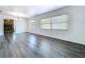Bright living room featuring sleek gray wood floors, white walls, and large windows at 2152 74Th N St, St Petersburg, FL 33710