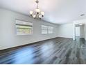 Spacious living room showcasing new wood floors, white walls, and natural light from large windows at 2152 74Th N St, St Petersburg, FL 33710