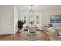 Bright dining area featuring a round table, chandelier and a bay window with views of the outdoor greenery at 2436 Nantucket Harbor Loop # 104, Sun City Center, FL 33573