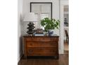 Hallway with a wooden dresser, mirror, lamp, and plant in decorative vase at 2911 W Estrella St, Tampa, FL 33629