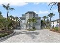 Stunning home with a circular tower, complemented by lush tropical landscaping and a large driveway at 297 1St W St, Tierra Verde, FL 33715