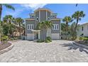 Stunning coastal home with a paver driveway, manicured landscaping, and a two-car garage at 297 1St W St, Tierra Verde, FL 33715
