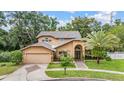 Elegant two-story home with a two-car garage, manicured lawn, and lush landscaping at 3013 Crest Dr, Clearwater, FL 33759