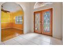 Bright entryway with decorative doors, tile floors and view into the living area at 3013 Crest Dr, Clearwater, FL 33759