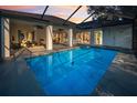 A sparkling pool surrounded by a screened-in patio, perfect for outdoor entertaining and relaxation at 3047 Lake Padgett Dr, Land O Lakes, FL 34639
