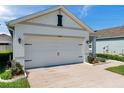 Spacious two-car garage with well-kept landscaping, offering convenience and ample parking at 32714 Brooks Hawk Ln, Wesley Chapel, FL 33543