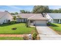 Charming single-story home boasting a well-kept lawn, mature palm trees, and a two-car garage at 3956 Tarpon Pointe Cir, Palm Harbor, FL 34684